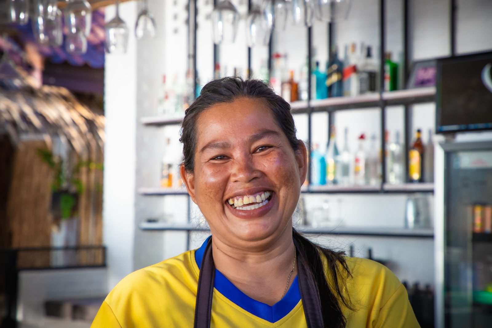 A woman who runs her own shop laughs behind the bar counter.